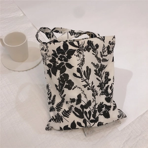Detailed view of the black floral fern pattern on the white cotton tote bag