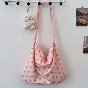 Detailed close-up of pink heart-patterned canvas tote bag with reinforced shoulder strap