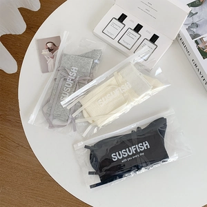 Three pairs of ballet-style ribbon bow socks in grey, beige, and black on a white table