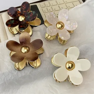 Elegant floral acetate and metal hair claw clips in four colors on white paper