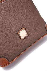 Detail of dark brown pebble leather bag with white stitching and golden metal plate