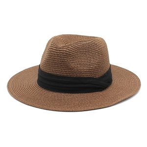 Close-up of brown straw Panama hat with black ribbon and detailed spiral weave texture
