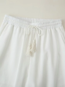Detailed view of elastic waistband on white cotton linen pants with tassel drawstring