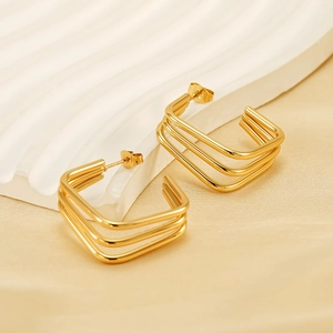 Three-layer geometric 18K gold-plated stainless steel stud earrings on a white silk base