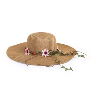 Close-up of fine straw weave texture and pink fabric floral detail on a summer sun hat