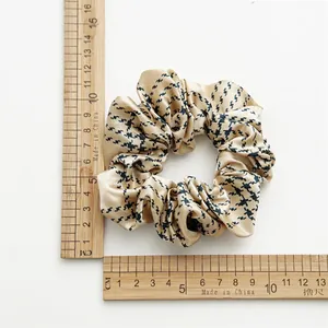 Satin champagne gold scrunchie with houndstooth pattern and 12cm diameter measurement