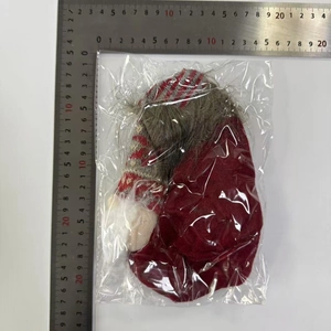 Close-up of a Christmas gnome decoration in red and white stripes with a grey beard