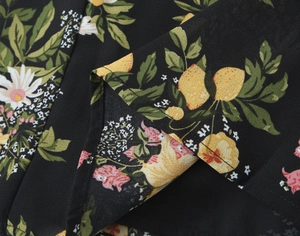 Detailansicht des Blumenmusters mit Zitronen und Gänseblümchen auf schwarzem Sommerkleid
