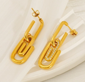 Vue macro de boucles d'oreilles trombone dorées avec détails en zircone scintillants