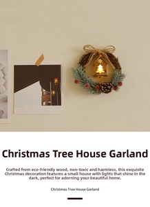 Close-up of lighted wooden house ornament inside a rustic Christmas pine wreath