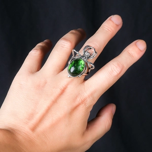 Gothic punk spider ring with green gemstone on hand in vintage silver finish