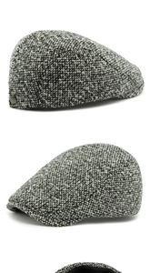 Close-up of black and white newsboy cap featuring tweed texture and metal button detail