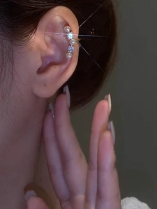Detailed view of gold ear cuff featuring alternating white pearls and clear cubic zirconia
