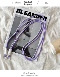 Detailed view of purple woven strap with white round carabiner on a magazine