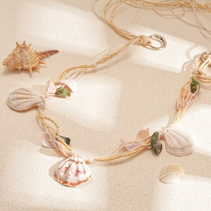 Detailed close-up of handmade raffia woven necklace with natural shells for beach vacations