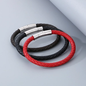 Détail de bracelets en cuir tressé rouge, noir et marron avec fermoir magnétique en acier