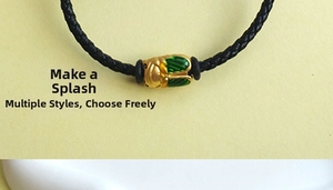Detail of hand-woven black cord bracelet with a gold and green cicada charm