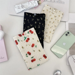 Dettaglio di pochette per cellulare in chiffon floreale con bottoni in tre fantasie colorate