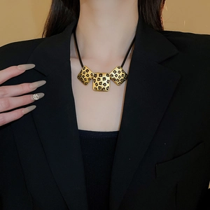 Detail einer eleganten Goldkette mit Leopardenmuster-Anhänger an einem weiblichen Model