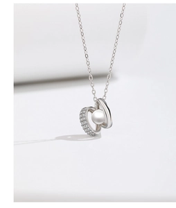 Macro shot of 925 silver double-loop necklace with cubic zirconia and fresh water pearl