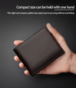 Compact dark brown leather men's wallet held in one hand showing its portable slim size