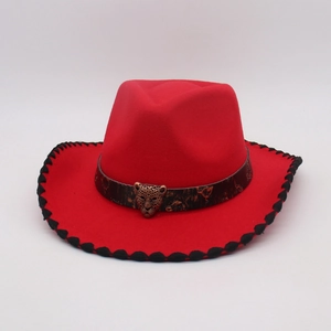 Detail of red felt cowboy hat with stitched brim and antique leopard metal badge