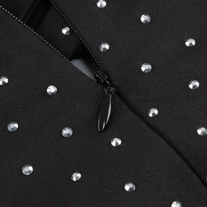 Detailed close-up of invisible zipper and sparkling rhinestones on black bandage dress