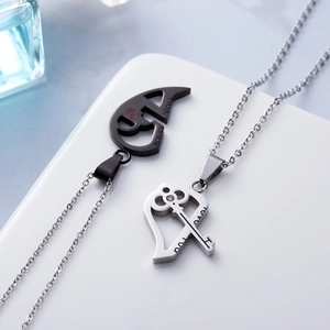 Macro shot of stainless steel couple necklaces with key and heart pendants and Love You engraving