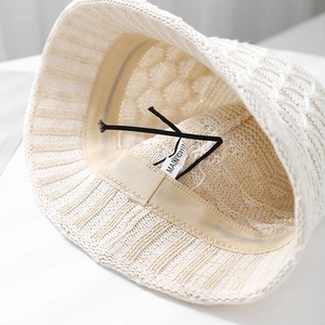 Detailed interior of a white knitted bucket hat showing sweatband and adjustable string