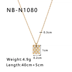 Dettaglio del ciondolo dorato a scacchi con dimensioni 1cm x 0,3cm e catena da 45cm