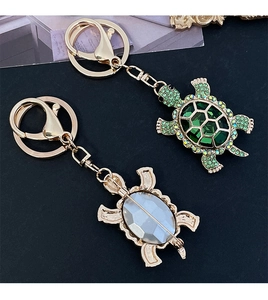 Detail of crystal turtle keychain with green rhinestones and versatile pin attachment