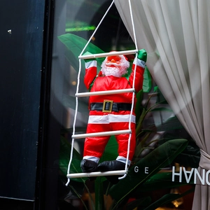 Dettaglio di Babbo Natale che sale su una scala di corda per decoro natalizio