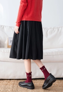 Close-up of wine red ribbed socks with lettuce trim and white pearl embellishments