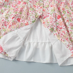 Detailed view of floral mini dress hem showing fine stitching and soft white lining