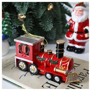 Detail of red Christmas train ornament with golden accents on a vintage book backdrop