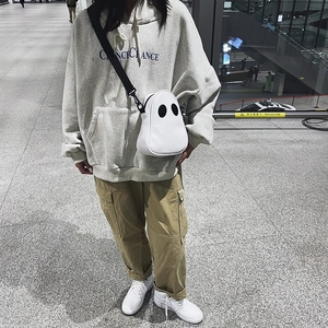 Outdoor shot of the cute white ghost crossbody bag with black adjustable strap