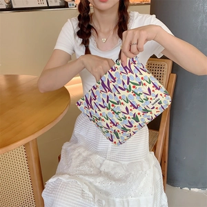 Detail of floral canvas makeup bag with tulip pattern and smooth zipper closure