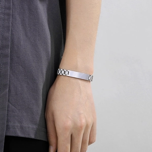 Close-up of men's silver stainless steel ID bracelet on wrist with adjustable links