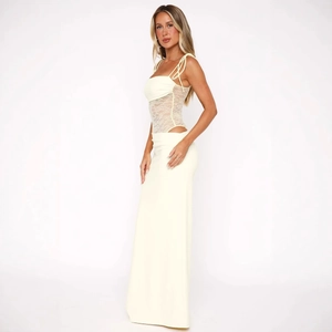Close-up of elegant lace patchwork and slim tie shoulder straps on a creamy yellow dress