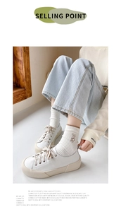 Detail of white cotton crew sock with small rabbit embroidery and low-top white sneakers