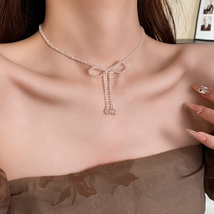Close-up of clear crystal bead bow necklace on model neck for elegant accessory styling