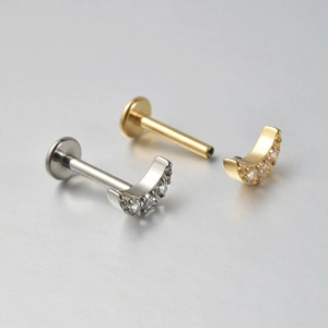 Detail of moon-shaped F136 titanium piercing with zircon inlay and flat back screw