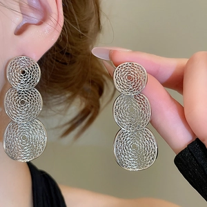 Detailed view of silver layered geometric drop earrings with hollow mesh disk pattern