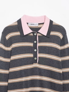Detail of the pink contrast collar and pearl buttons on a striped knit polo shirt
