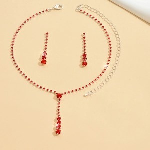 Detailed view of silver necklace and earrings set with vibrant round red gemstones