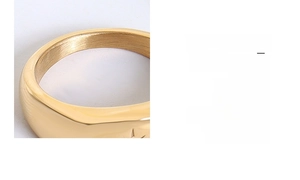 Détail macro d'une bague en titane plaqué or montrant l'intérieur brossé et la gravure d'étoile