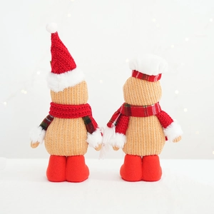 Rear view of two knitted gingerbread man plushies with red scarves and Christmas hats