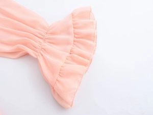 Detailed macro view of pink chiffon double-layered ruffle cuffs and bell sleeve design