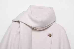 Detail of cream wool blend coat showing soft texture and amber buttons