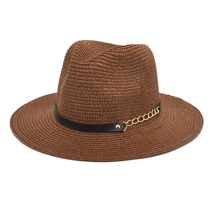Close-up of brown woven sun hat featuring a black leather band and gold metal chain